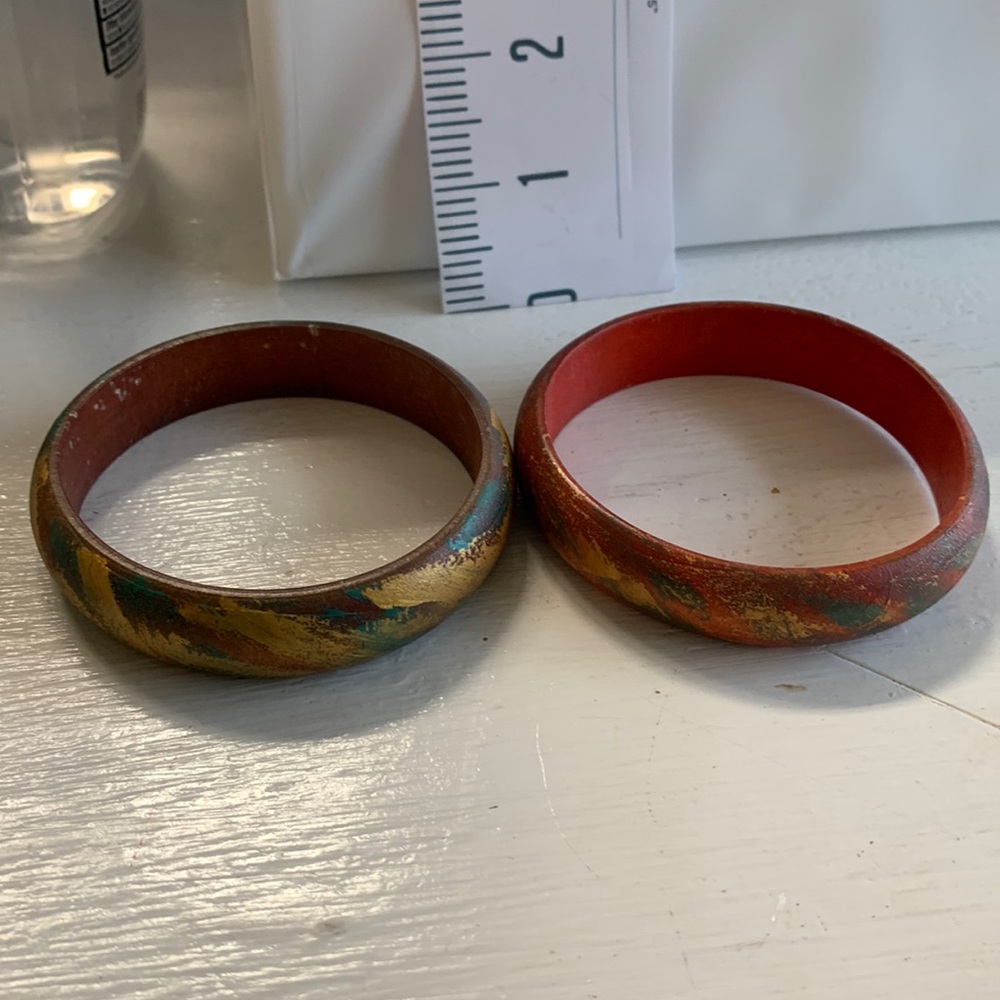 Set of 2 1/2” wide painted wood bangle bracelets.